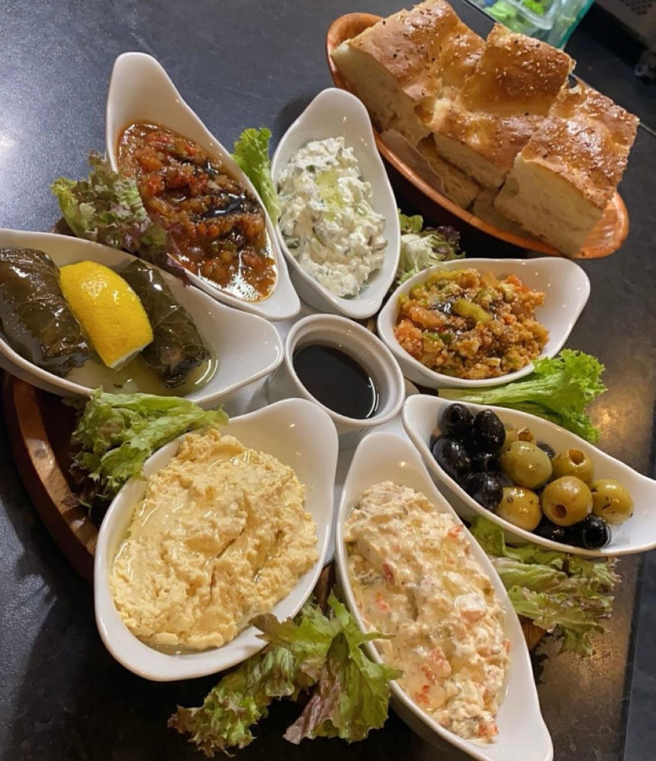 Traditional Turkish meze platter with hummus, dolma, olives, and fresh bread