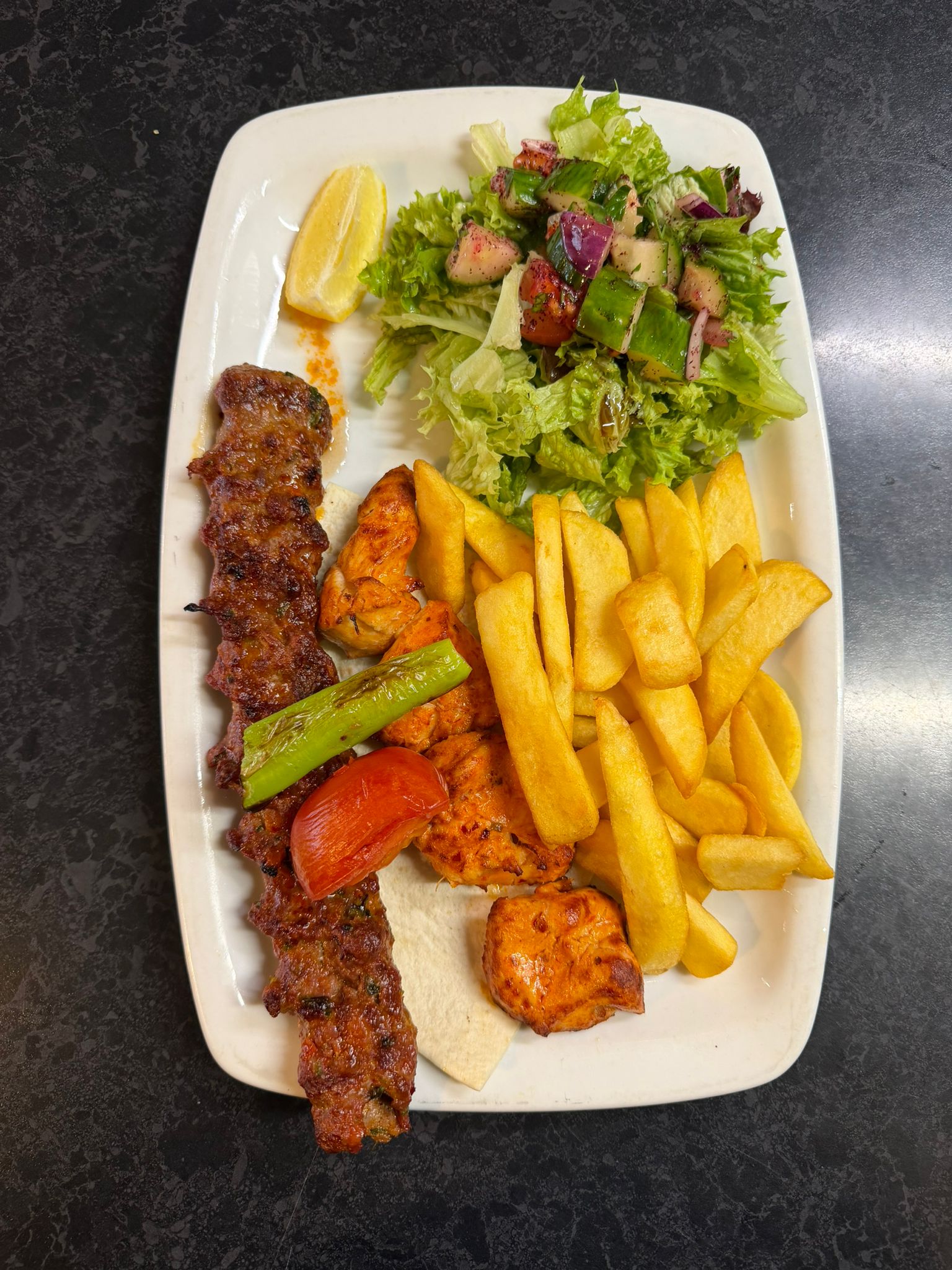 Mixed grill plate with kebab, chicken and golden chips